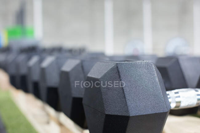 Row of heavy metal dumbbells for intense functional training arranged together in modern sports club — Stock Photo