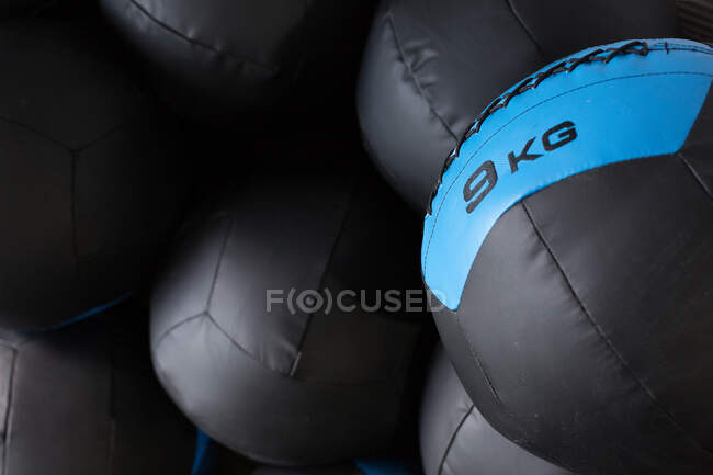 Set of black medicine balls for functional training stacked in rows near wall in modern sports club — Stock Photo