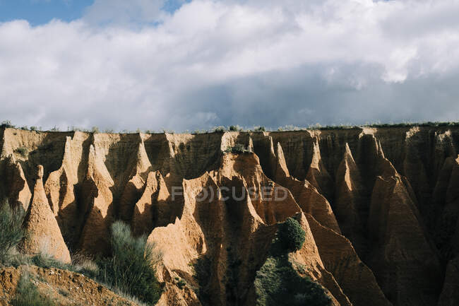 Scenery view of gorge with dry surface surrounded by green mount on sunny day in Spain — Stock Photo
