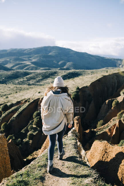 Back view of unrecognizable female tourist standing on gorge contemplating green mountains in Spain — Stock Photo