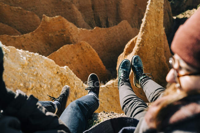 From above of crop tourist speaking with anonymous friend while resting against ravine on sunny day — Stock Photo