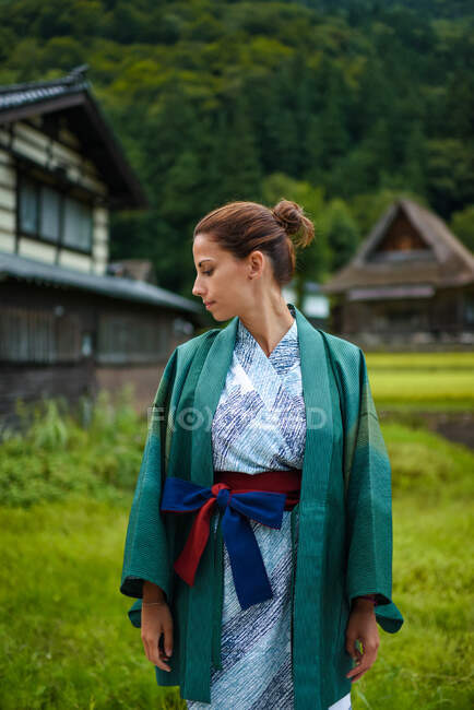 Veduta laterale ritratto di giovane donna caucasica attraente contemplativa che indossa un tradizionale kimono giapponese nel piccolo villaggio di Ainokura, Giappone — Foto stock