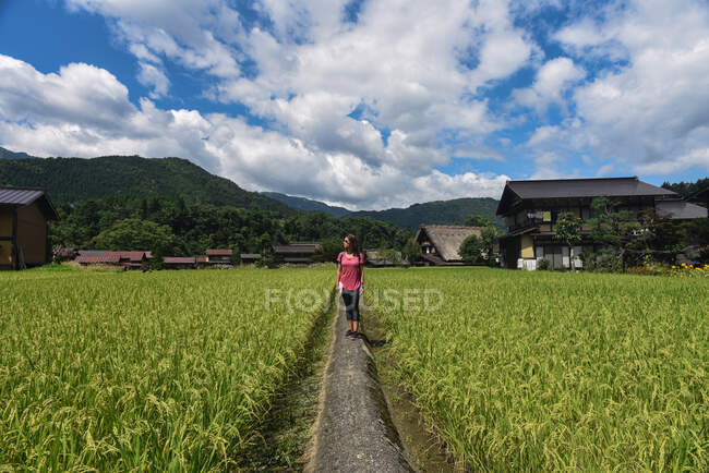 Junge kaukasische Frau auf freiem Feld in einem historischen japanischen Dorf und UNESCO-Weltkulturerbe Shirakawa-Go, Japan — Stockfoto