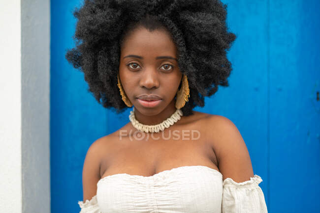 Young African American female in trendy summer outfit standing near building on old street in city — Stock Photo