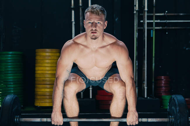 Strong male athlete doing deadlift with heavy barbell during workout in gym — Stock Photo