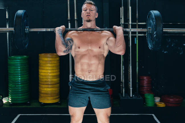 Atleta masculino forte fazendo deadlift com barra pesada durante o treino no ginásio — Fotografia de Stock