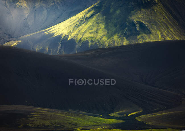 Удивительный мирный вид на холмистую местность, покрытую пышной зеленью в ясную погоду в Исландии — стоковое фото
