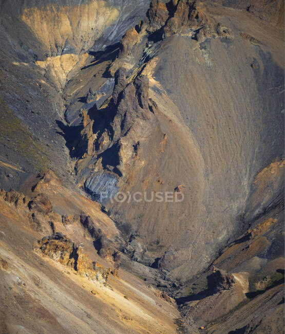 D'en haut paysage spectaculaire de terrain rocheux rugueux sans fin avec des pentes sèches et une végétation aléatoire situé en Islande — Photo de stock