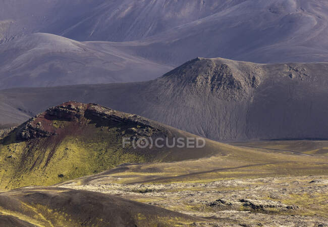 Сценический вид грубых скалистых образований в окружении холмистой зеленой долины — стоковое фото