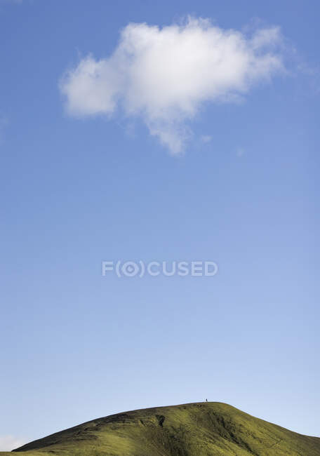 Мальовничі пейзажі пухнастої хмари, що плавають на прозорому блакитному небі над зеленим трав'янистим верхом на справедливій погоді — стокове фото
