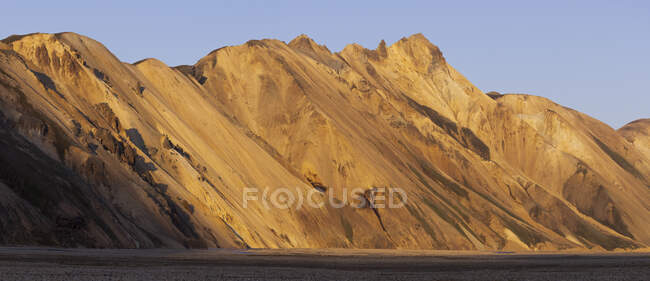Magnificent scenery of rocky mountains with peaks illuminated by sunlight in rough desert terrain in Iceland — Stock Photo