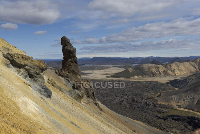 Spectacular landscape of endless rough rocky terrain with dry slopes and random vegetation located under clear blue sky in Iceland — Stock Photo