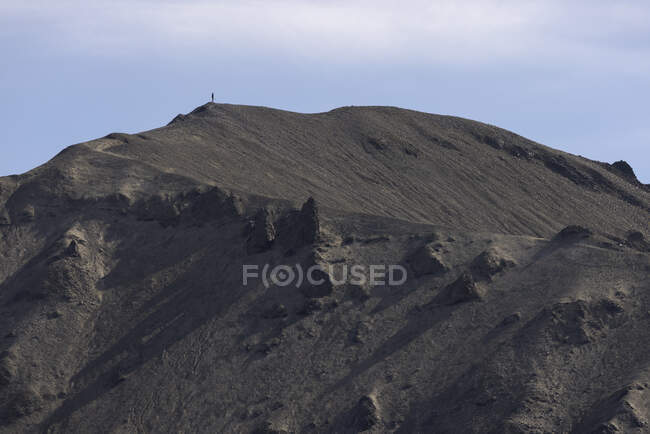 Scenic view of rough rocky volcanic formations surrounded by hilly dry mountain — Stock Photo