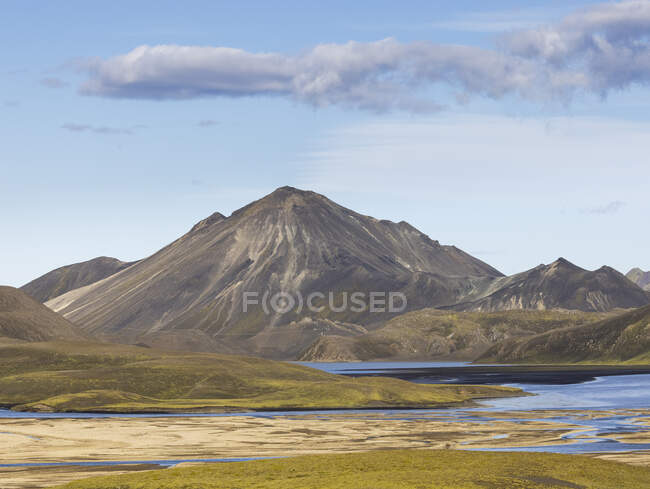 Meraviglioso scenario di freddo lago cristallino circondato da una catena montuosa ruvida coperta di vegetazione secca nelle giornate limpide — Foto stock