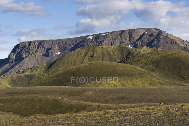 Великолепный пейзаж скалистых гор с вершинами, освещенными солнечным светом на пересеченной местности пустыни в Исландии — стоковое фото
