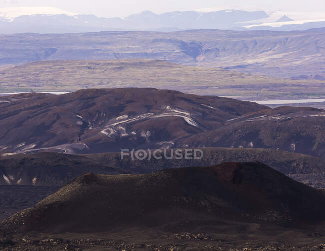 Scenic view of rough rocky volcanic formations surrounded by hilly dry mountain — Stock Photo