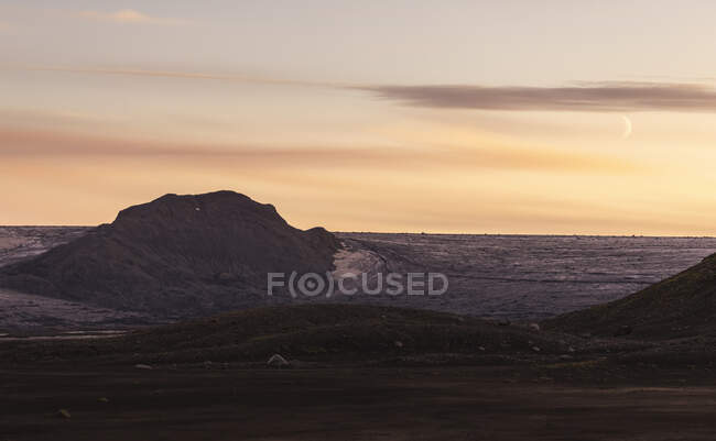 Vista panoramica di formazioni rocciose vulcaniche grezze circondate da monti collinari asciutti — Foto stock