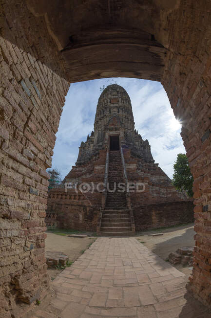 Bajo ángulo de piedra antigua Wat Chaiwatthanaram templo budista con escaleras que conducen a la entrada ubicada en el Parque Histórico de Ayutthaya - foto de stock