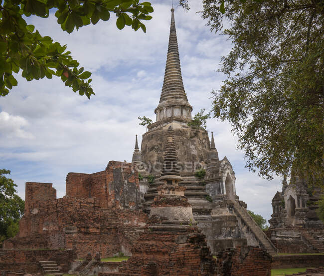 De baixo da antiga Wat Phra Si Sanphet templo budista com stupas localizado contra o céu nublado em Ayutthaya, na Tailândia — Fotografia de Stock