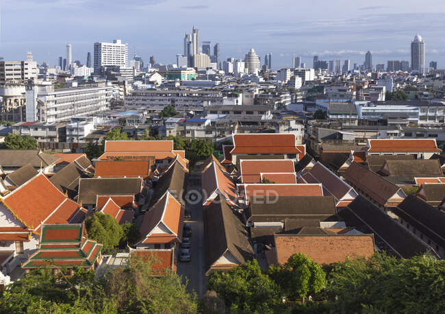 Espectacular paisaje urbano de Bangkok con edificios contemporáneos del famoso templo budista Wat Saket contra el cielo azul nublado - foto de stock