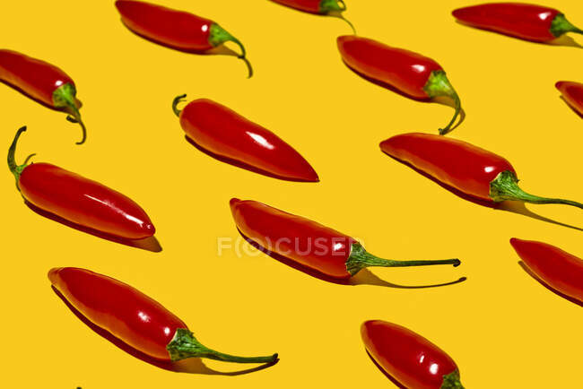 From above of fresh ripe chili peppers on yellow background — Stock Photo