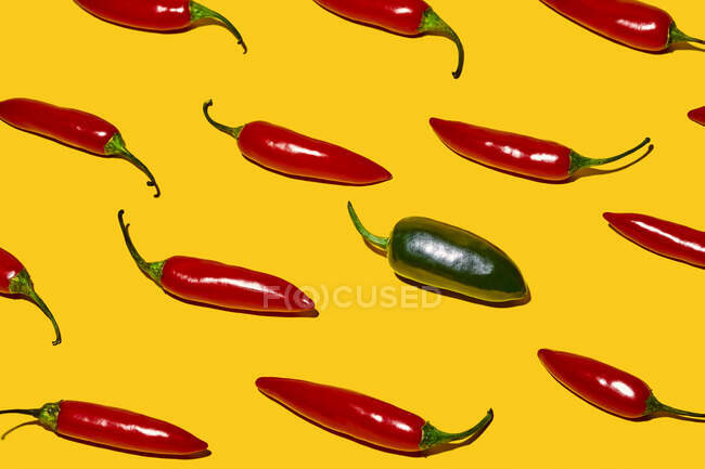 Зверху свіжий стиглий перець чилі з гарячим зеленим овочем різного роду на жовтому фоні — стокове фото