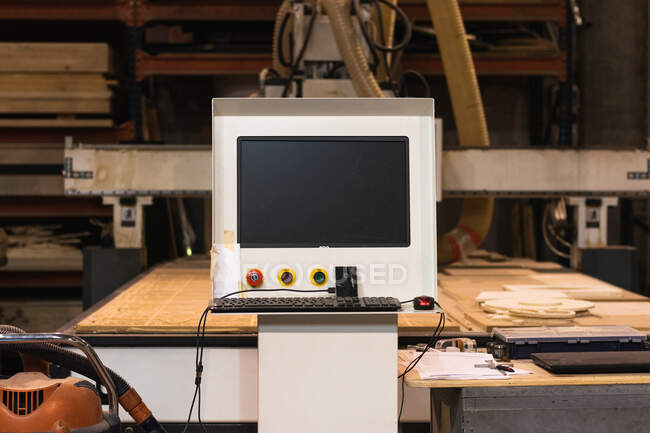 Старомодное компьютерное цифровое управление гранж-машиной, размещенной в обветшалой столярной мастерской — стоковое фото