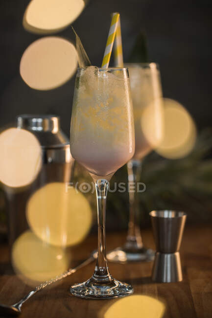 Из выше композиции сладкие классические коктейли Пина Колада подается на барной стойке возле шейкера и jigger — стоковое фото
