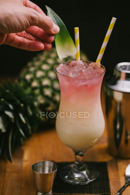Crop faceless person preparing delicious refreshing Pina Colada cocktail served on table — Stock Photo