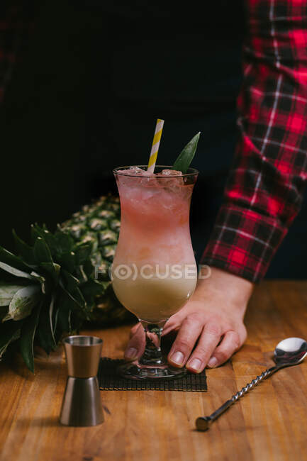 Pessoa sem rosto colheita preparando delicioso refrescante coquetel Pina Colada servido na mesa — Fotografia de Stock