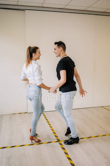 Талантливая пара, исполняющая бальные танцы во время репетиций в светлой просторной студии — стоковое фото