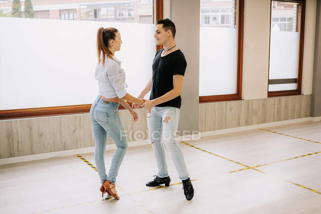 Талановита пара виконує бальний танець під час репетицій у світлій просторій студії з дзеркалом під час занять — стокове фото