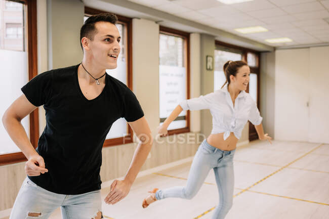 Coppia di talento che esegue balli da sala mentre prova in uno spazioso studio luminoso con specchio durante la lezione — Foto stock