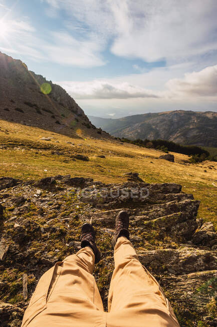 Невідомий турист у повсякденному одязі лежачи на необжитій землі проти гір під час подорожі до Іспанії. — стокове фото