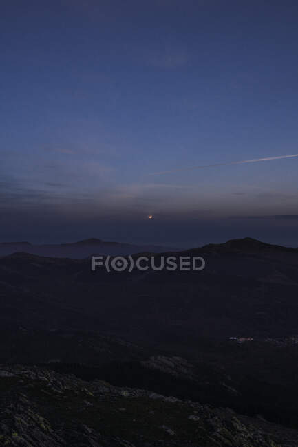 Szenische Ansicht der Silhouetten der Berge unter blauem bewölkten Himmel mit Sonne in der Nacht in Europa — Stockfoto