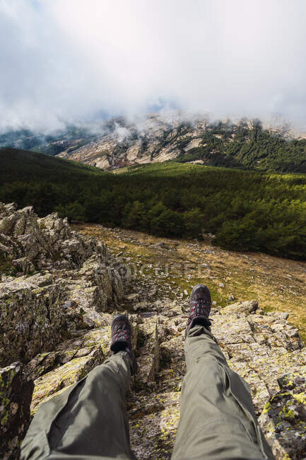 Crop anonymous tourist in casual wear lying on rough land against mountains during trip in Spain — Stock Photo