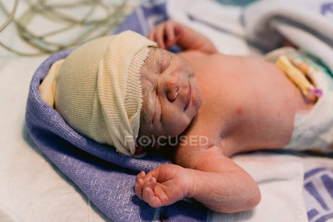 Крупный план новорожденного ребенка, завернутого в одеяло после родов в больнице — стоковое фото