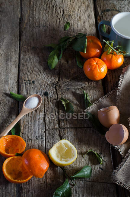 Зверху асортименту інгредієнтів для мандаринового мусу, розташованого на дерев'яному столі на кухні — стокове фото