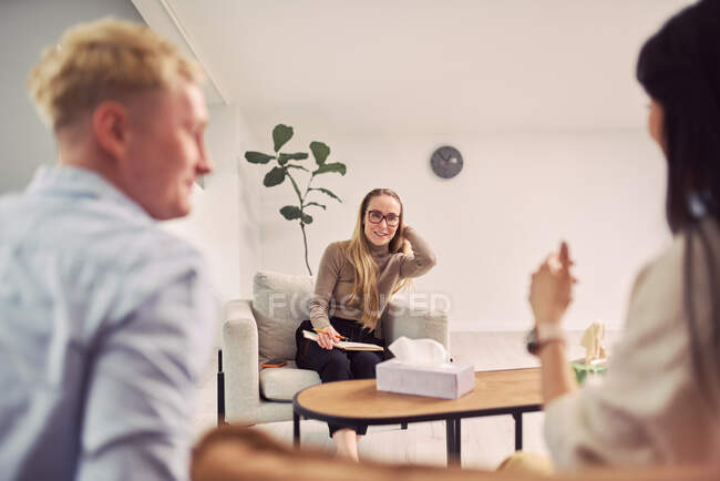 Multiethnisches Paar sitzt auf der Couch und spricht während einer Therapiesitzung mit Psychologen über psychische Probleme — Stockfoto