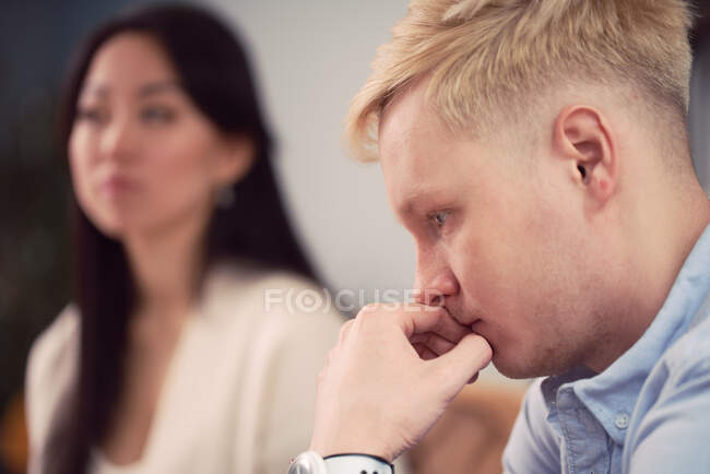 Mulher asiática infeliz levando ao homem indiferente durante sessão de terapia no escritório do psicólogo — Fotografia de Stock
