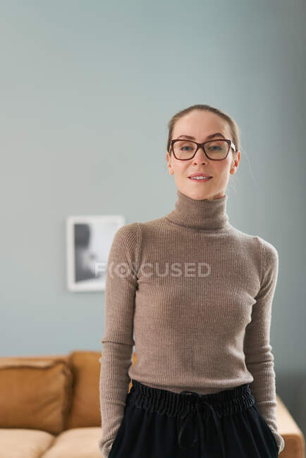 Sorrindo auto-confiante conselheira feminina de pé com as mãos nos bolsos no escritório para sessões de psicoterapia e olhando para a câmera — Fotografia de Stock