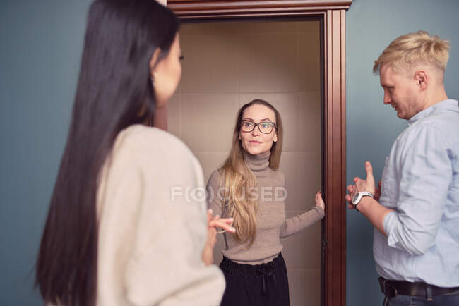 Female psychologist standing in doorway of office during appointment with couple having problems in relationship — Stock Photo