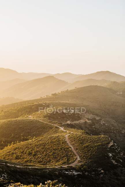 Spectacular scenery of winding road in highland area under sunset sky in evening — Stock Photo