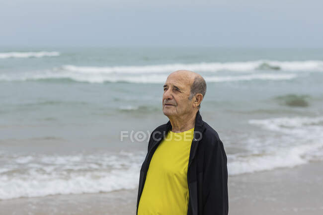 Älterer Sportler beim Fitnesstraining im Sommer am Strand in der Nähe des winkenden Meeres — Stockfoto