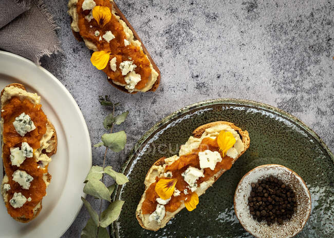 Vista dall'alto appetitosi toast freschi con marmellata e formaggio di capra serviti su piatti e tavolo di marmo — Foto stock