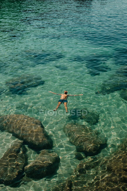 Hombre flotando en el mar durante el verano - foto de stock