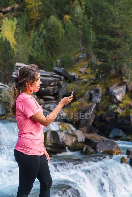 Vista laterale dell'escursionista femminile orientata con bussola nelle montagne dei Pirenei durante il viaggio nel Parco Nazionale di Ordesa y Monte Perdido — Foto stock