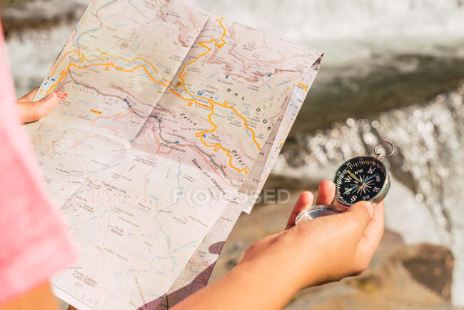 Невпізнавана подорожня жінка стоїть з паперовою картою поблизу водоспаду в Національному парку Ордеса - і - Монте - Пердідо і орієнтується під час відпустки в горах Піренеїв. — стокове фото
