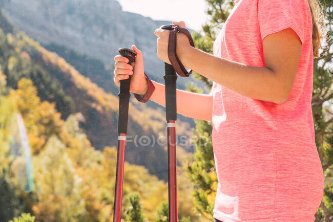 Seitenansicht unkenntliche Wanderin mit Trekkingstöcken, die im Nationalpark Ordesa y Monte Perdido steht und an sonnigen Tagen den Urlaub in den Pyrenäen genießt — Stockfoto