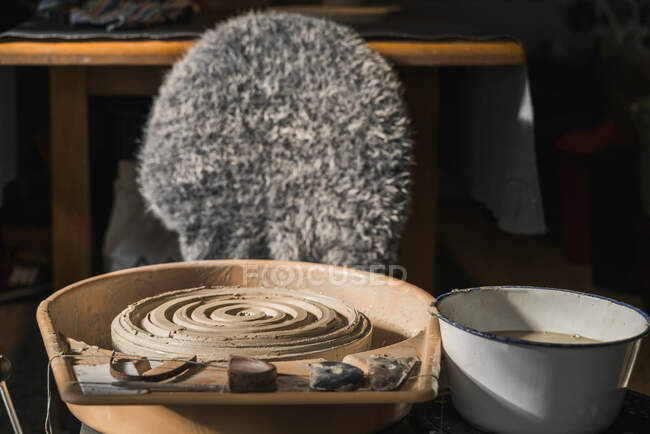 Roda de cerâmica suja e argila colocada com cadeira em oficina criativa de artesão — Fotografia de Stock
